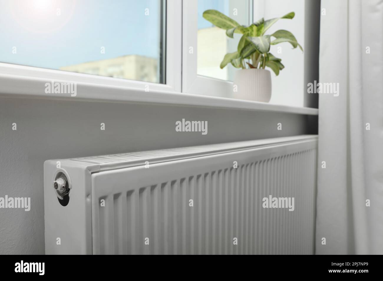 Modern radiator under window at home. Central heating system Stock