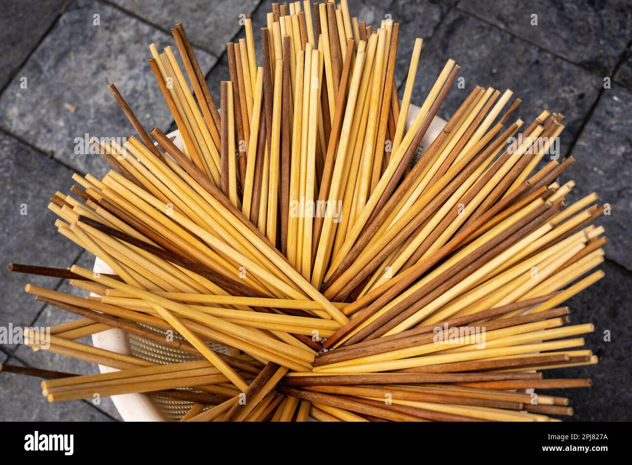 A bucket full of clean wooden chopsticks at a street stall in Hanoi