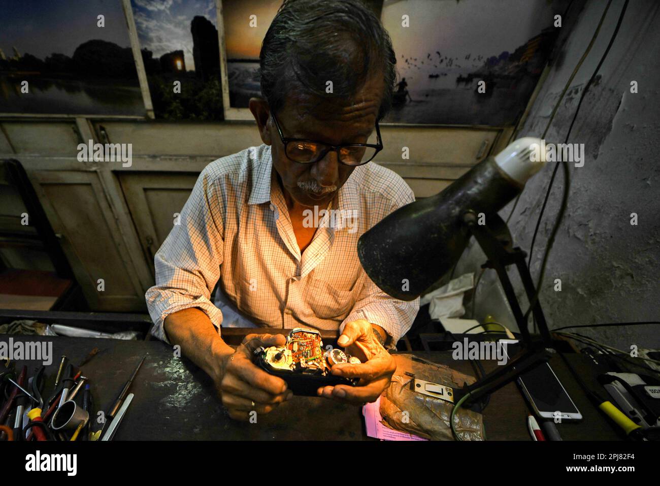 Kolkata, India. 31st Mar, 2023. A camera technician repairs an analog