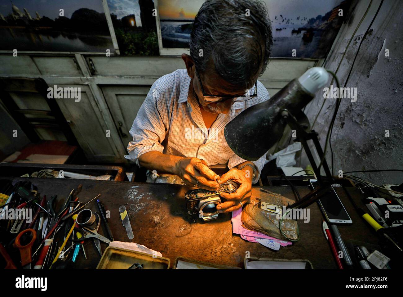 Kolkata, India. 31st Mar, 2023. A camera technician repairs an analog
