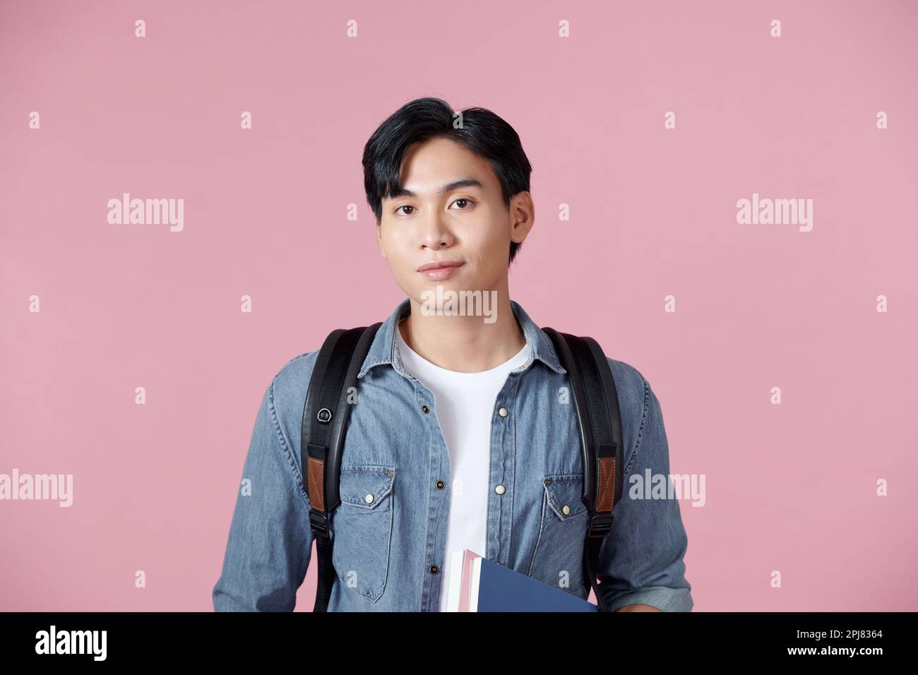 Portrait of smiling young college student with books and backpack ...