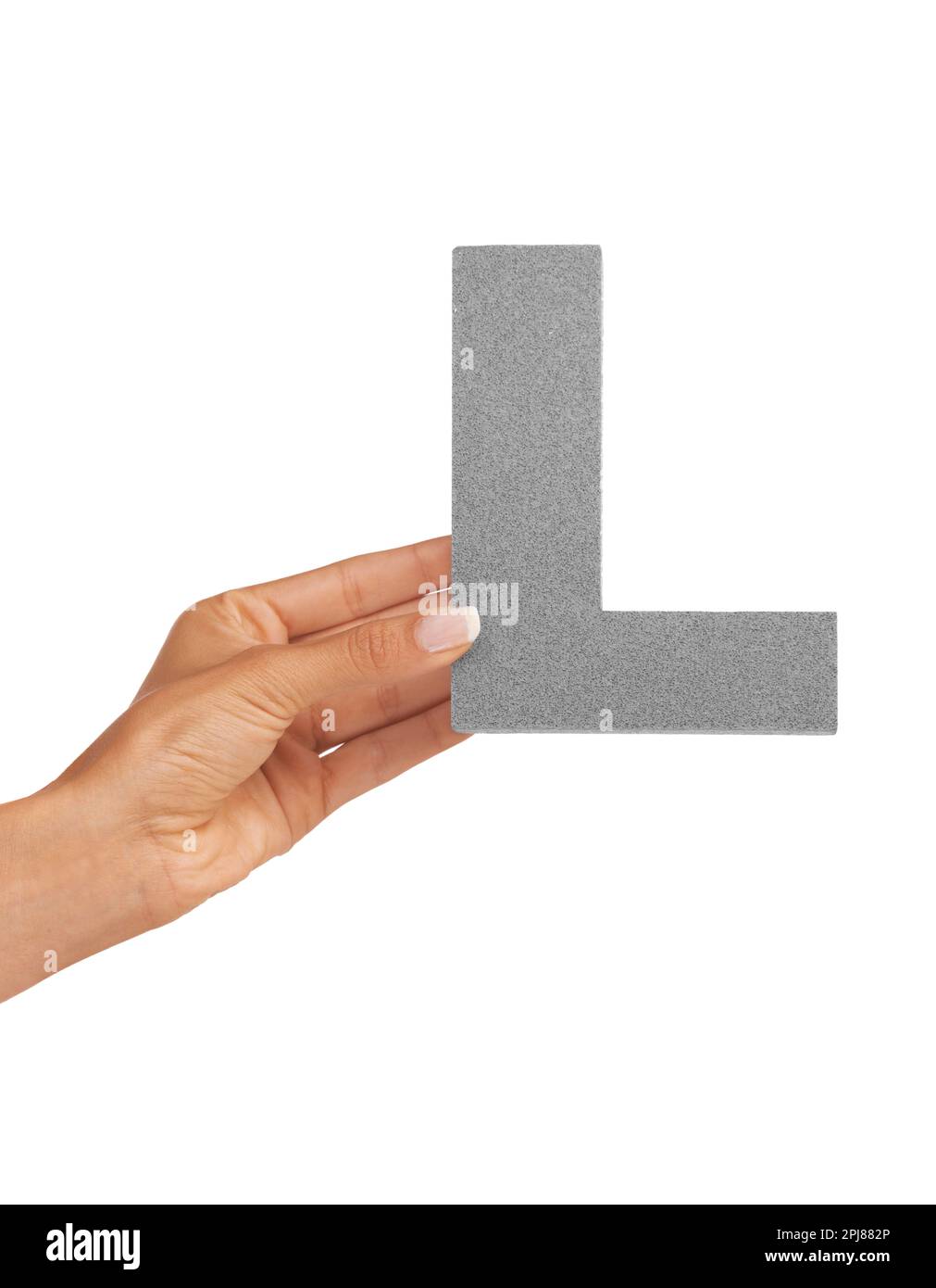 L is for learning. A young woman holding a capital letter L isolated on a white background. Stock Photo