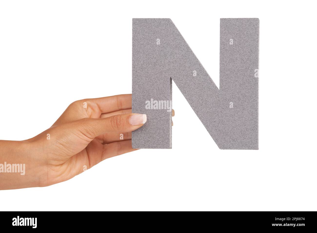 An N in hand. A young woman holding a capital letter N isolated on a white background. Stock Photo