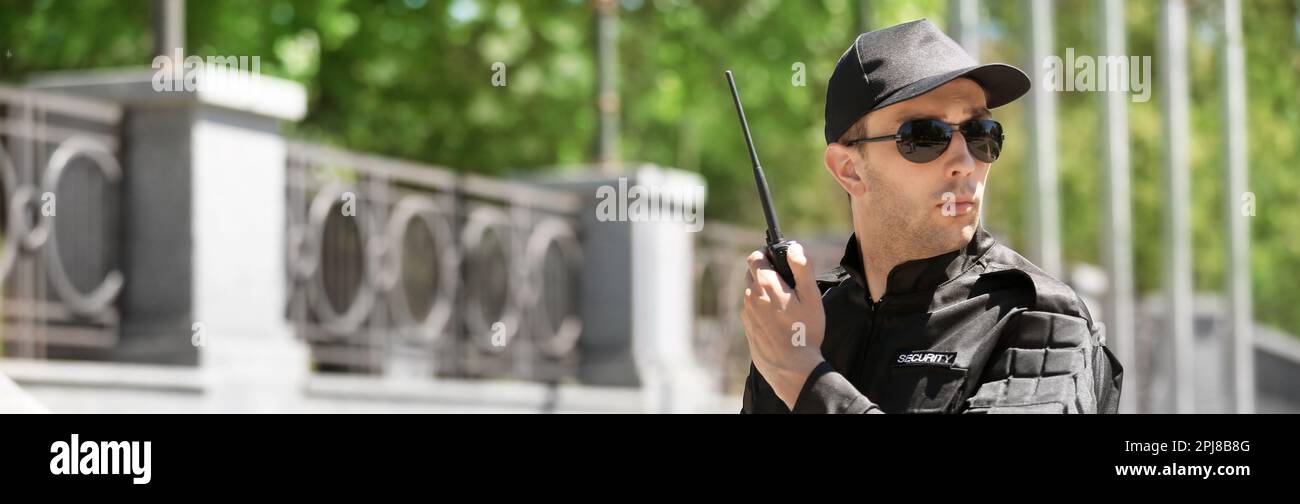 Male security guard using portable radio transmitter outdoors. Banner design Stock Photo Alamy