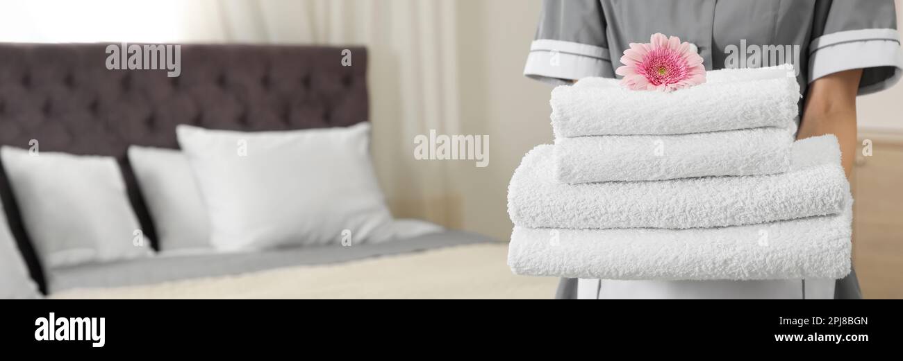https://c8.alamy.com/comp/2PJ8BGN/chambermaid-with-stack-of-fresh-towels-in-hotel-room-closeup-view-with-space-for-text-banner-design-2PJ8BGN.jpg