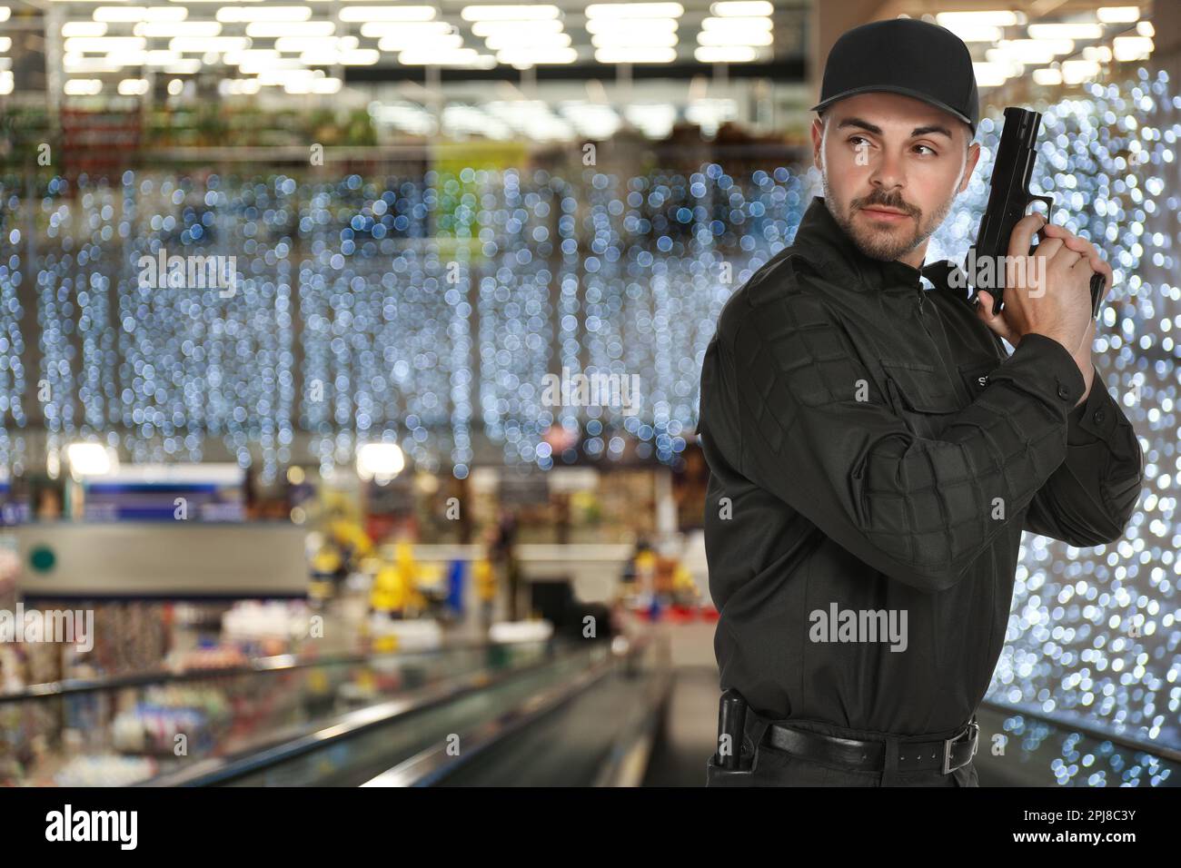 Male security guard wearing uniform with gun in shopping mall Stock