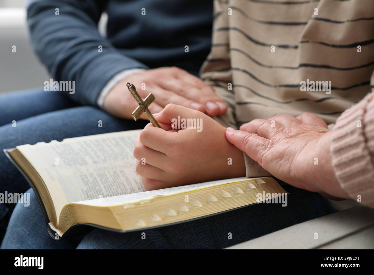 Boy and his godparents praying together, closeup Stock Photo