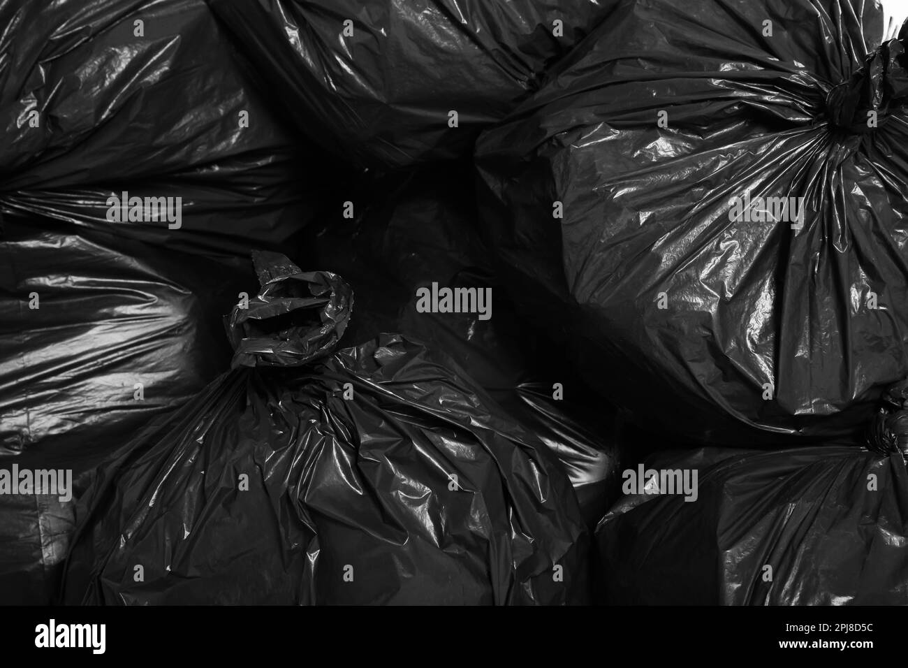 Black trash bags full of garbage as background, top view Stock Photo