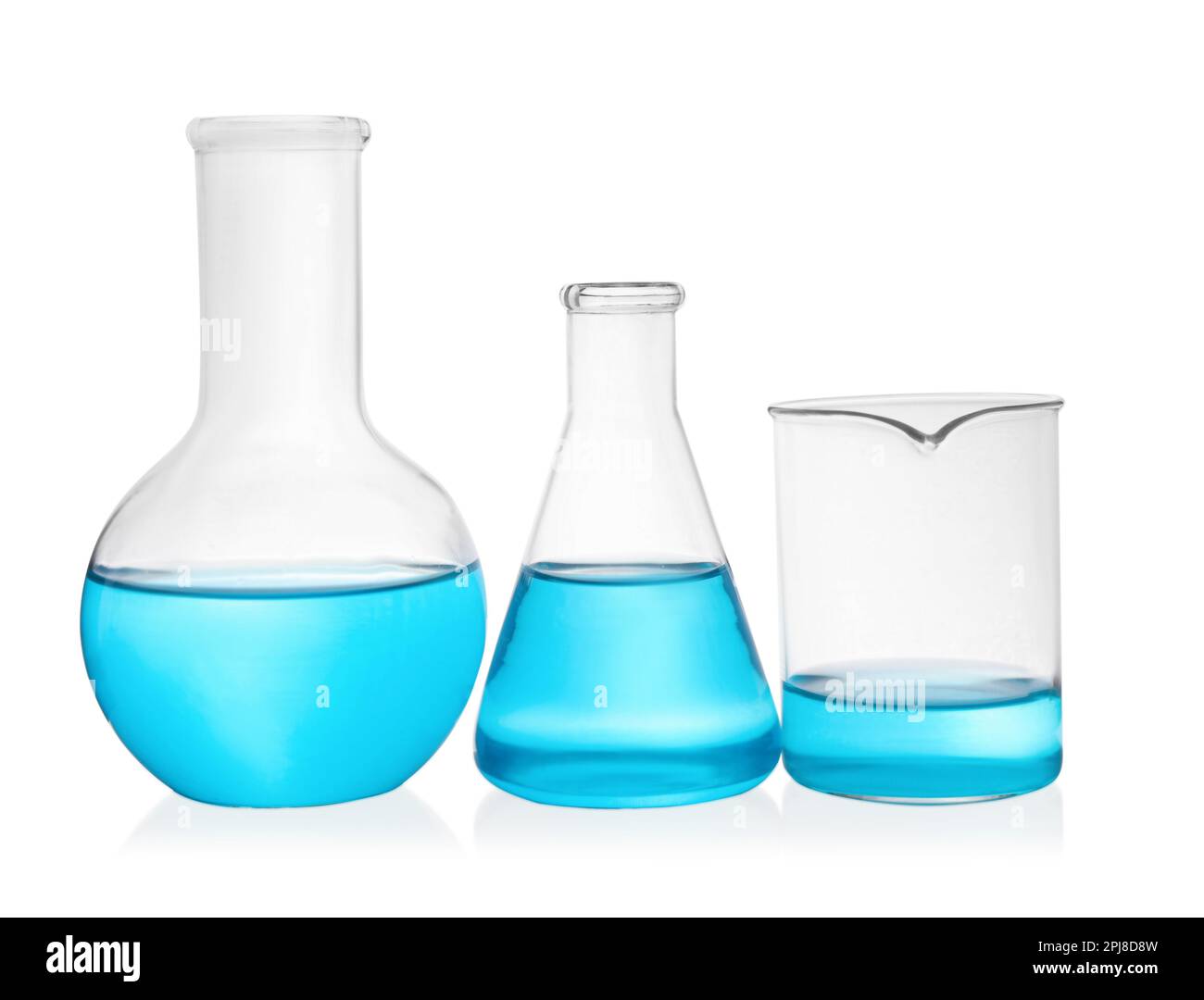 Different laboratory glassware with light blue liquid on white ...