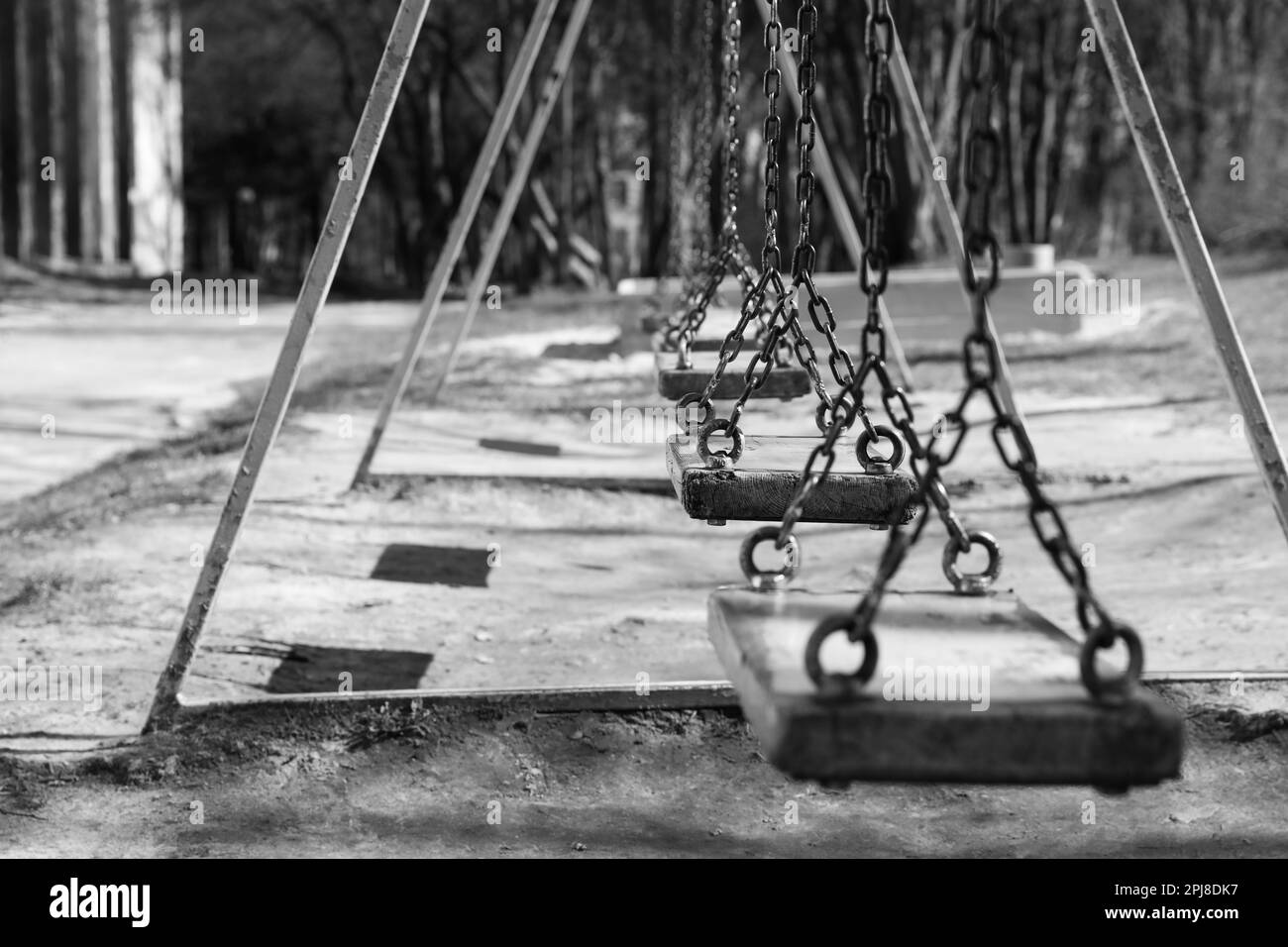 Wooden swings in park, space for text. Black and white effect Stock