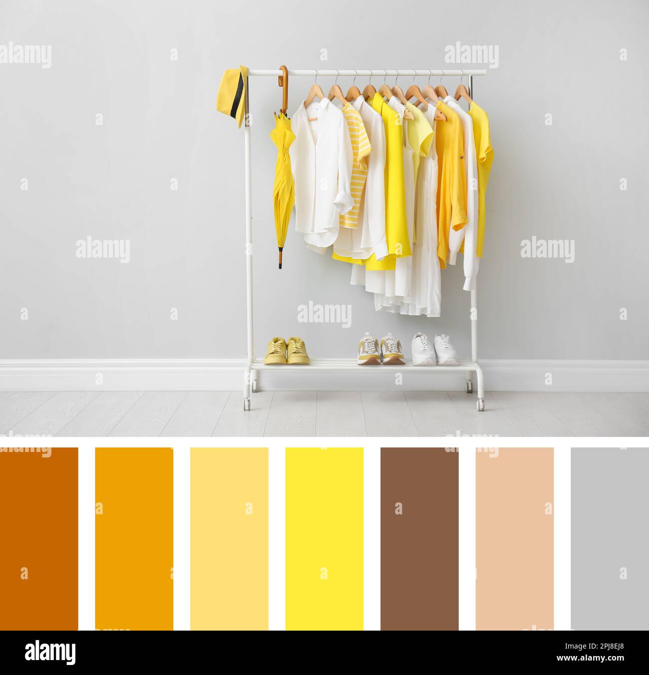 Rack with bright stylish clothes, shoes and accessories near grey wall indoors. Composition inspired by colors of the year 2021 Stock Photo