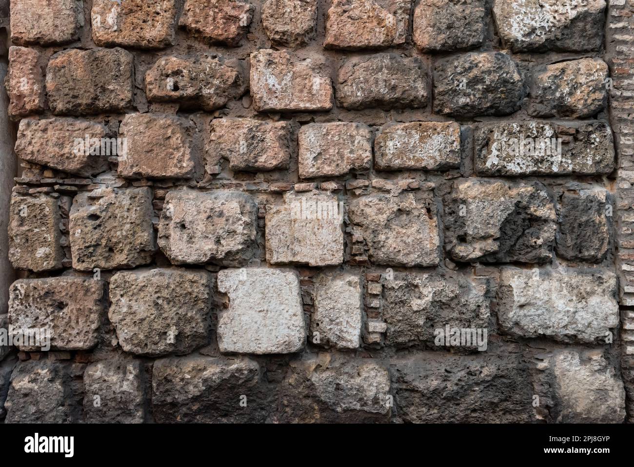 Stone and brick wall of an ancient building. Suitable as background and wallpaper pattern. Stock Photo