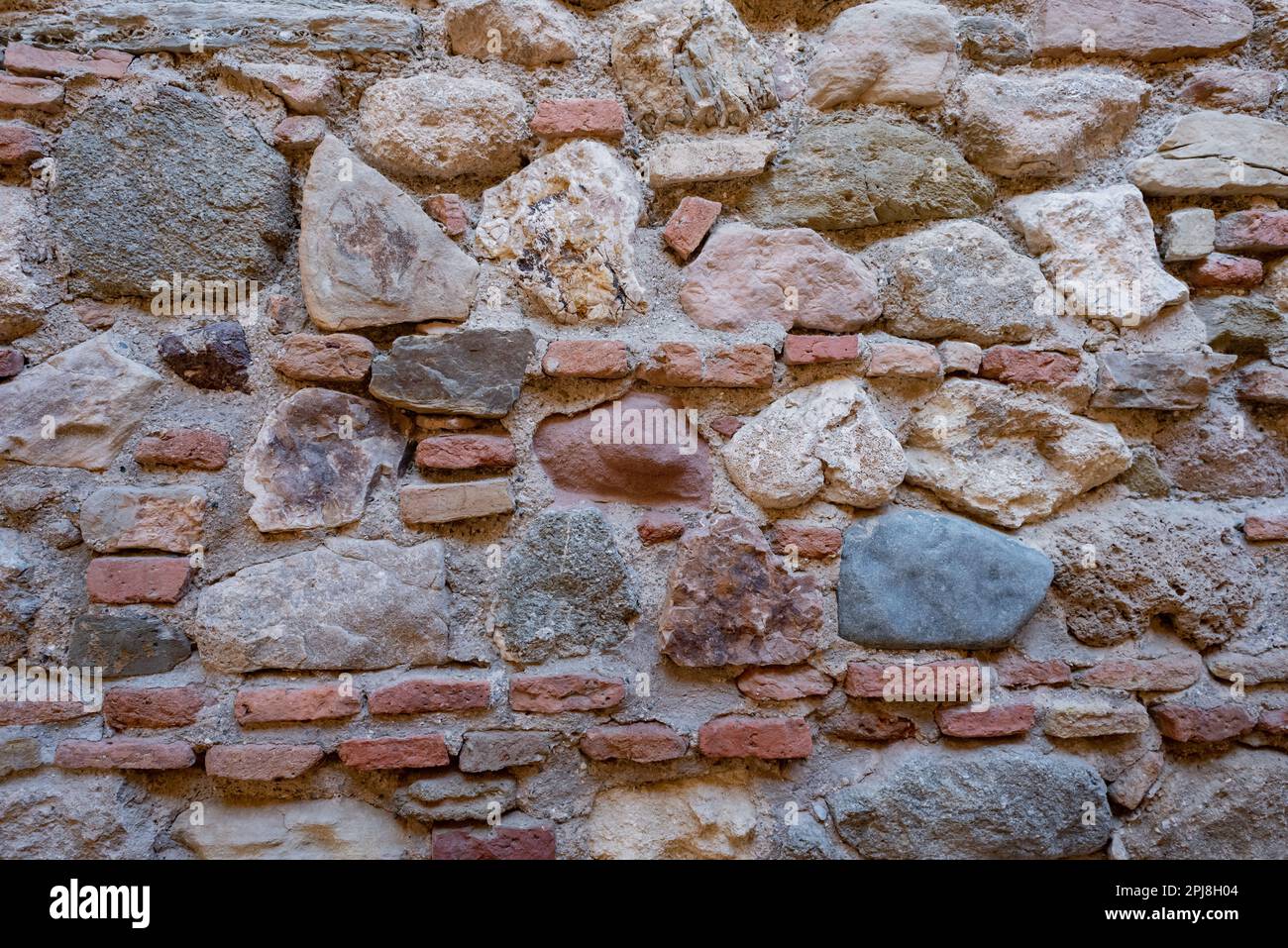 Stone and brick wall of an ancient building. Suitable as background and wallpaper pattern. Stock Photo