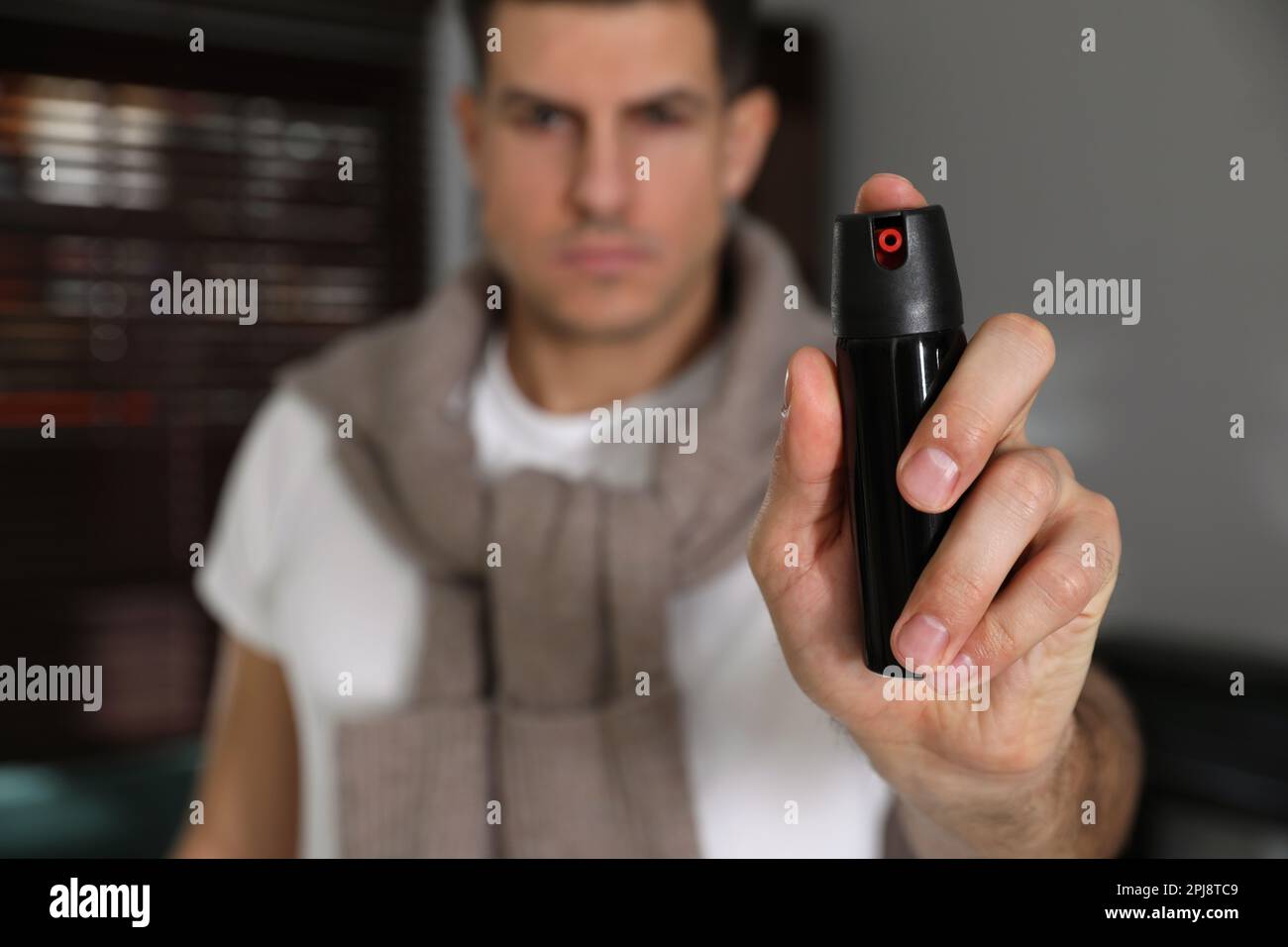 Man using pepper spray indoors, focus on hand Stock Photo Alamy