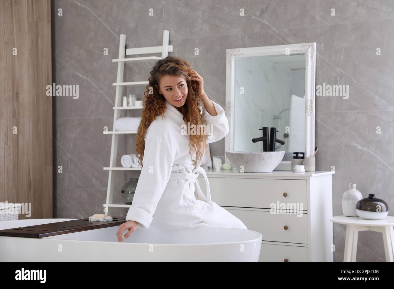 Beautiful woman in soft white robe near bathtub at home Stock Photo Alamy