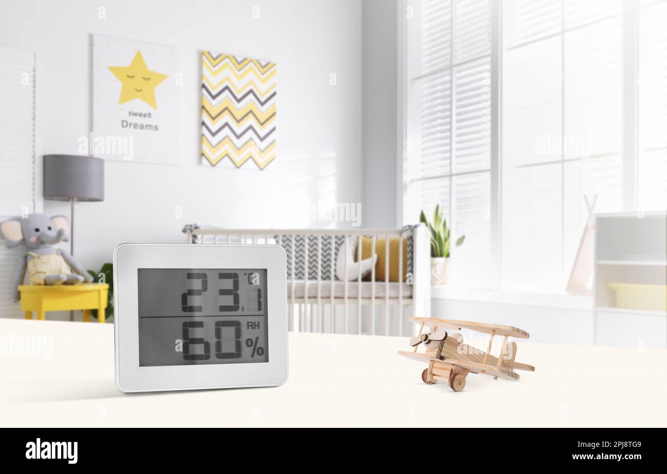 Digital hygrometer with thermometer on white table in children's room
