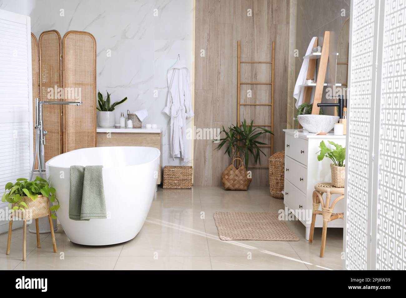 Modern white tub and beautiful green houseplants in bathroom. Interior ...