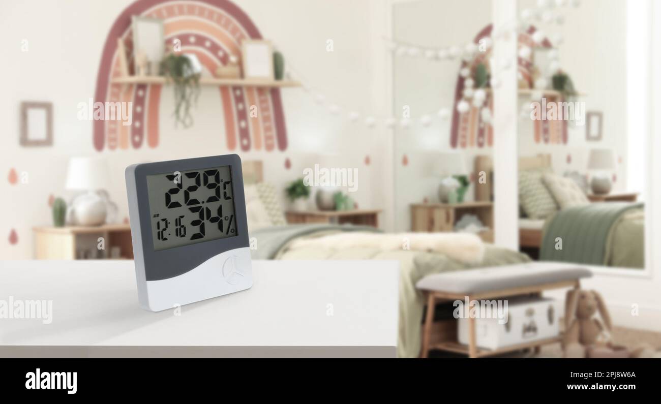 Digital hygrometer with thermometer on white table in children's room