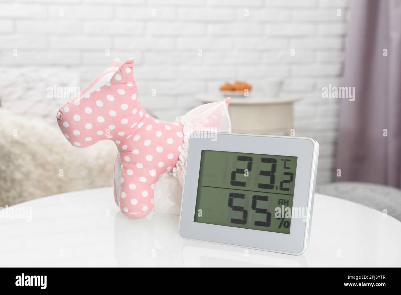 Digital hygrometer with thermometer on table in children's room