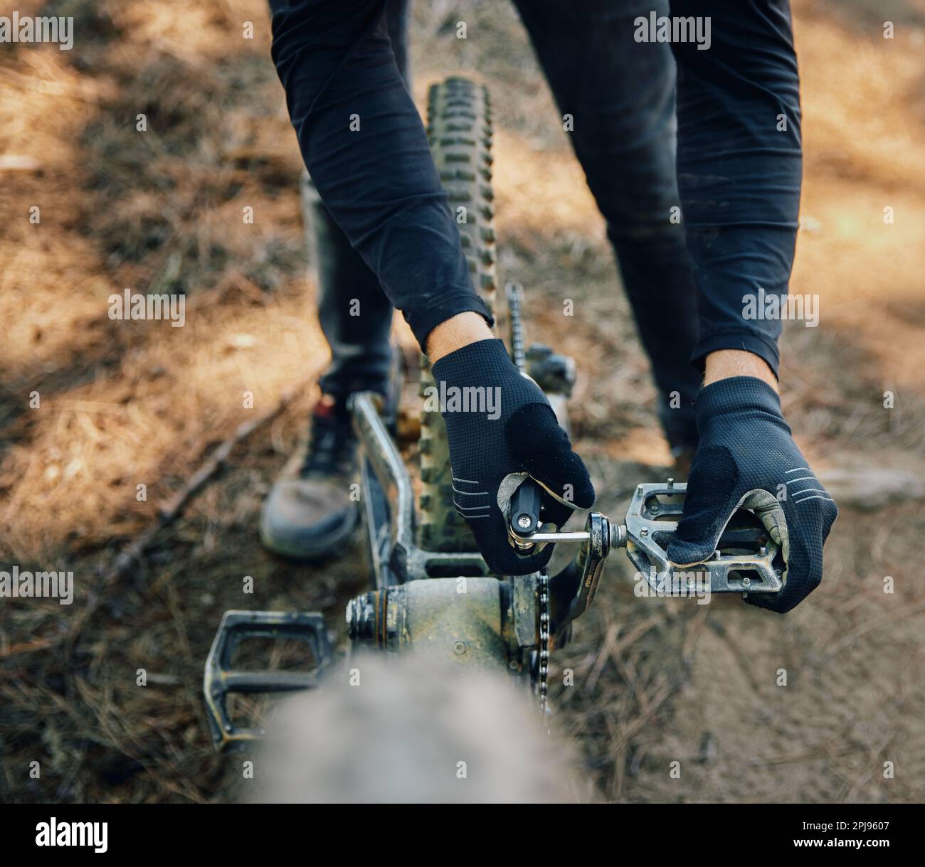 Hands, bicycle and repair pedal in woods for speed, dirt and nature in