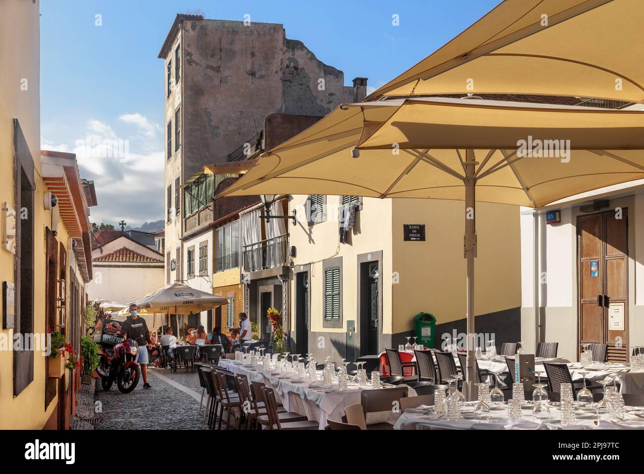 FUNCHAL, PORTUGAL - AUGUST 20, 2021: This is a lot of cafes and restaurants waiting and receiving guests in the narrow streets in the old seaside area Stock Photo
