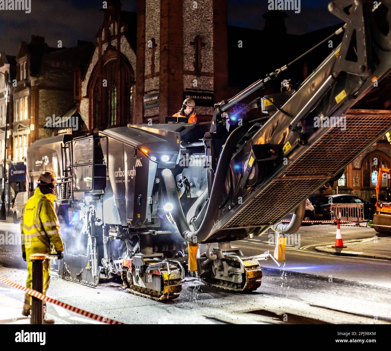 A massiveTarmac cutting machine is seen here in an urban city high street operating at night to avoid disruption during the day. Stock Photo