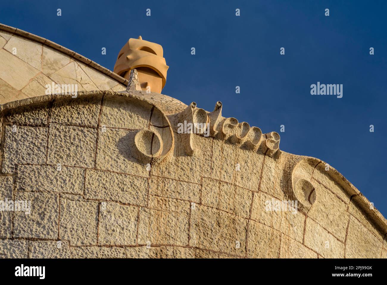 Detail of the upper garniture of the façade of La Pedrera - Casa Milà and a chimney on the roof (Barcelona, Catalonia, Spain) Stock Photo