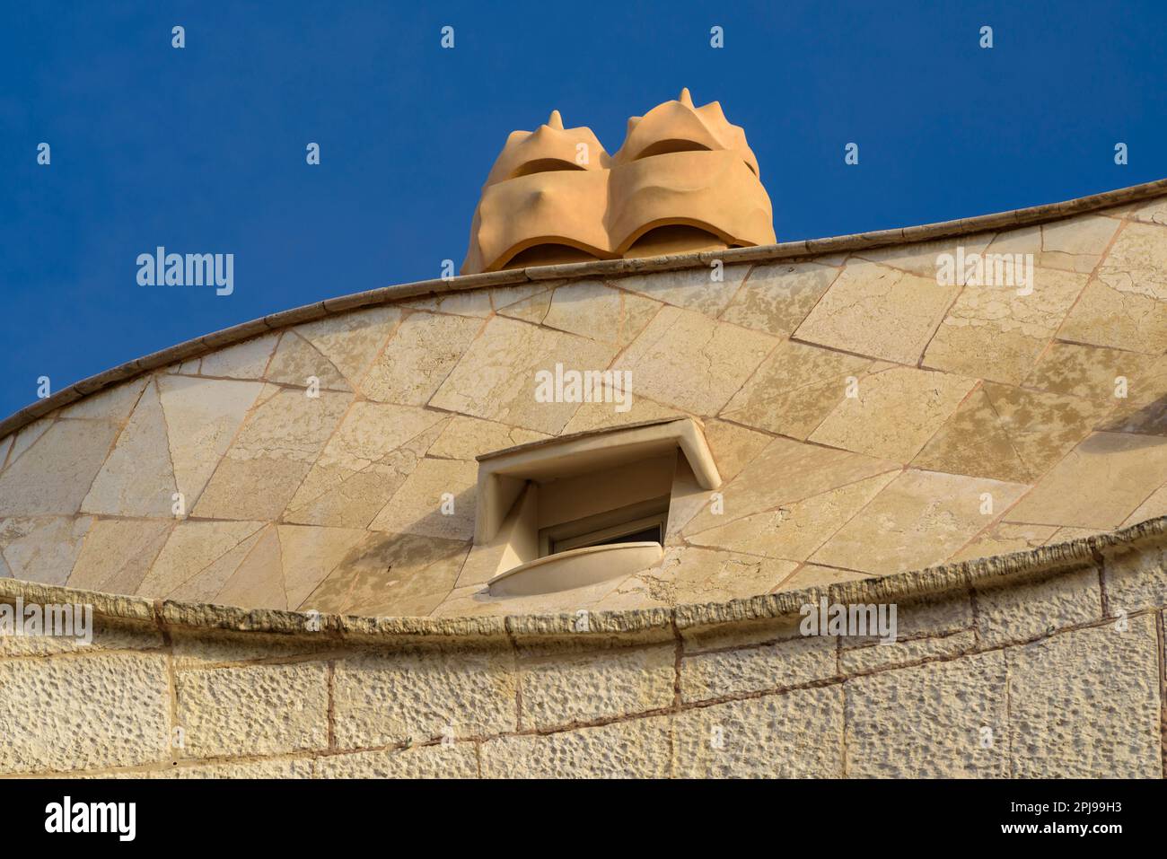 Detail of the upper garniture of the façade of La Pedrera - Casa Milà and a chimney on the roof (Barcelona, Catalonia, Spain) Stock Photo