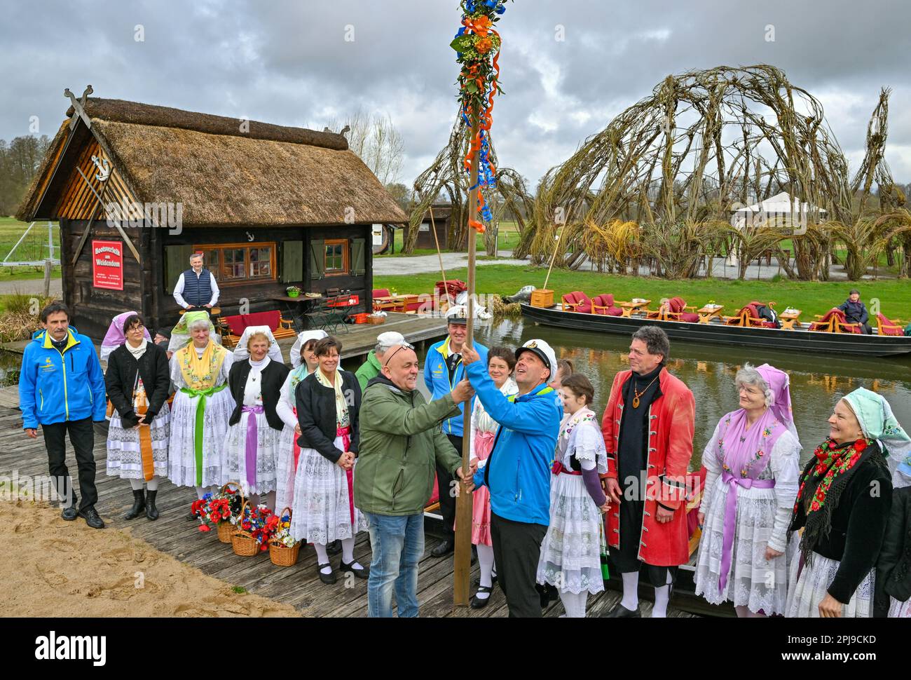 Schlepzig, Germany. 01st Apr, 2023. Women in Sorbian-Wendish festive costumes and bargemen take part in the season opening at the harbor at the Weidendom in the Spreewald village of Schlepzig. At the opening of the season, the rudel (wooden pole for moving the barge) is ceremoniously handed over to a bargeman. At the same time in several places in the Spreewald took place the traditional season opening with Rudelübergabe. Credit: Patrick Pleul/dpa/Alamy Live News Stock Photo