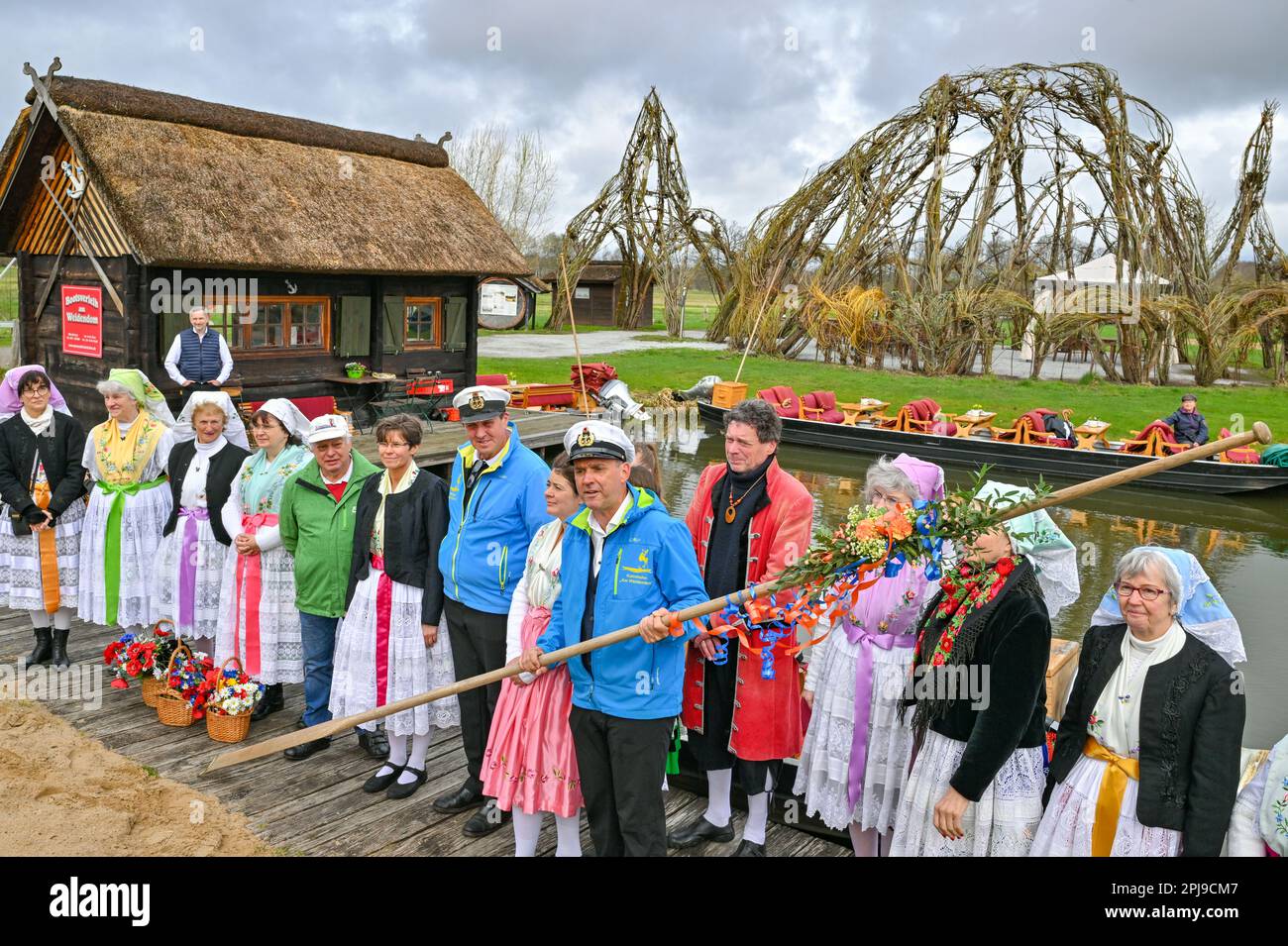 Schlepzig, Germany. 01st Apr, 2023. Women in Sorbian-Wendish festive costumes and bargemen take part in the season opening at the harbor at the Weidendom in the Spreewald village of Schlepzig. At the opening of the season, the pack (wooden pole for moving the barge) is ceremoniously handed over to a bargeman. At the same time, the traditional opening of the season with the handing over of the pack took place in several places in the Spreewald. Credit: Patrick Pleul/dpa/Alamy Live News Stock Photo