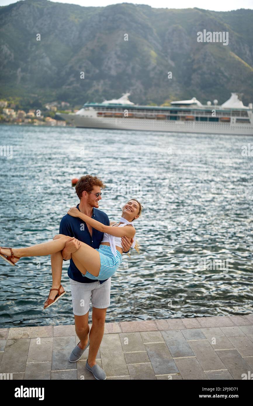 Couple on dock. Man holding woman in his arms. Beautiful sea view enjoying freedom. Travel, love, togetherness, lifestyle concept. Stock Photo