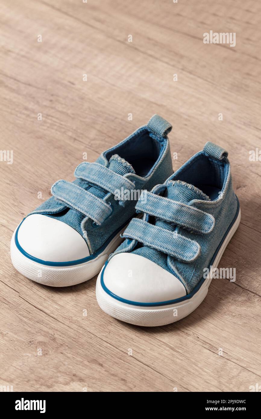 Children's sneakers of blue color on a wooden floor Stock Photo - Alamy