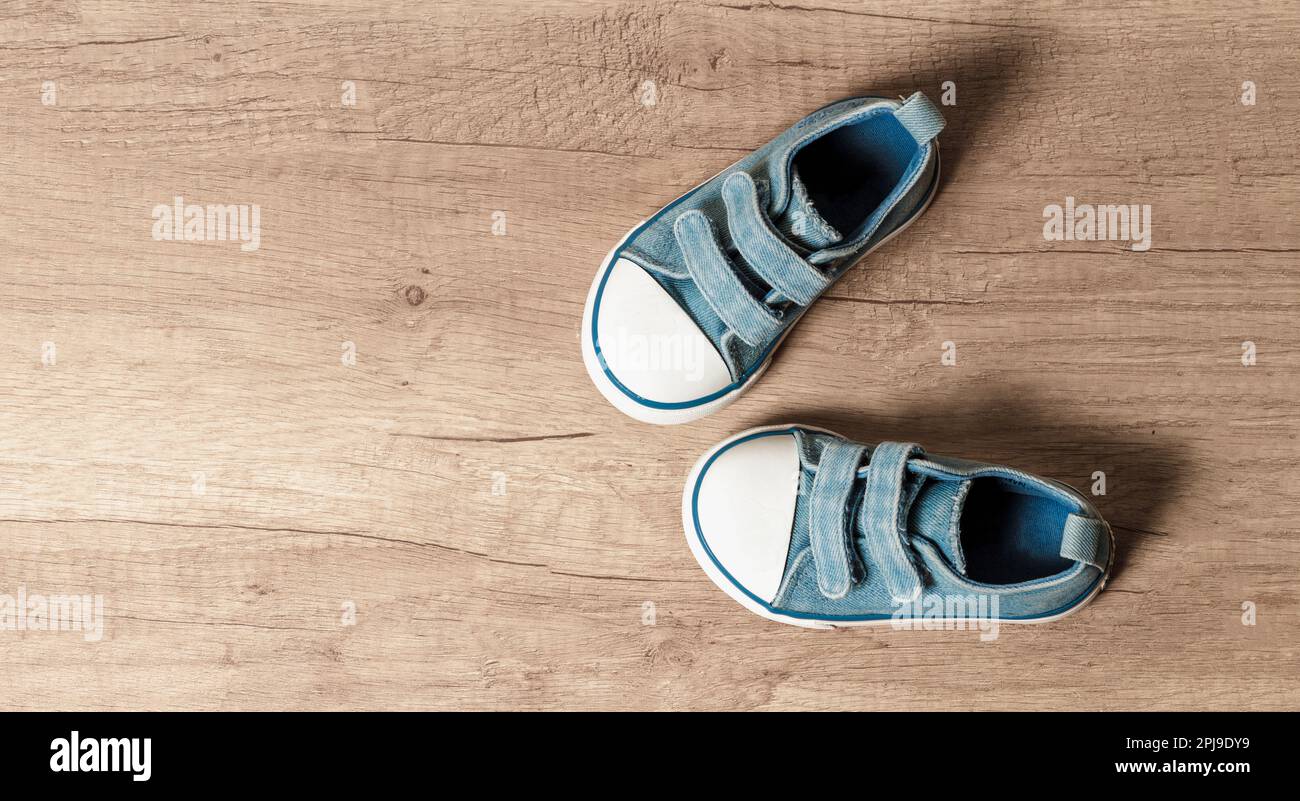 Children's sneakers of blue color on a wooden floor Stock Photo - Alamy