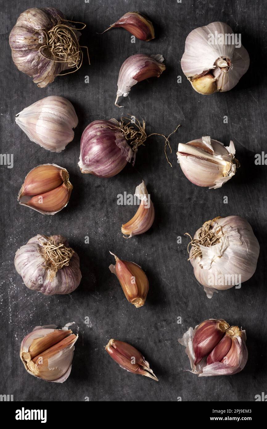 Fresh garlic bulbs and cloves grouped on black background. Flat lay ...