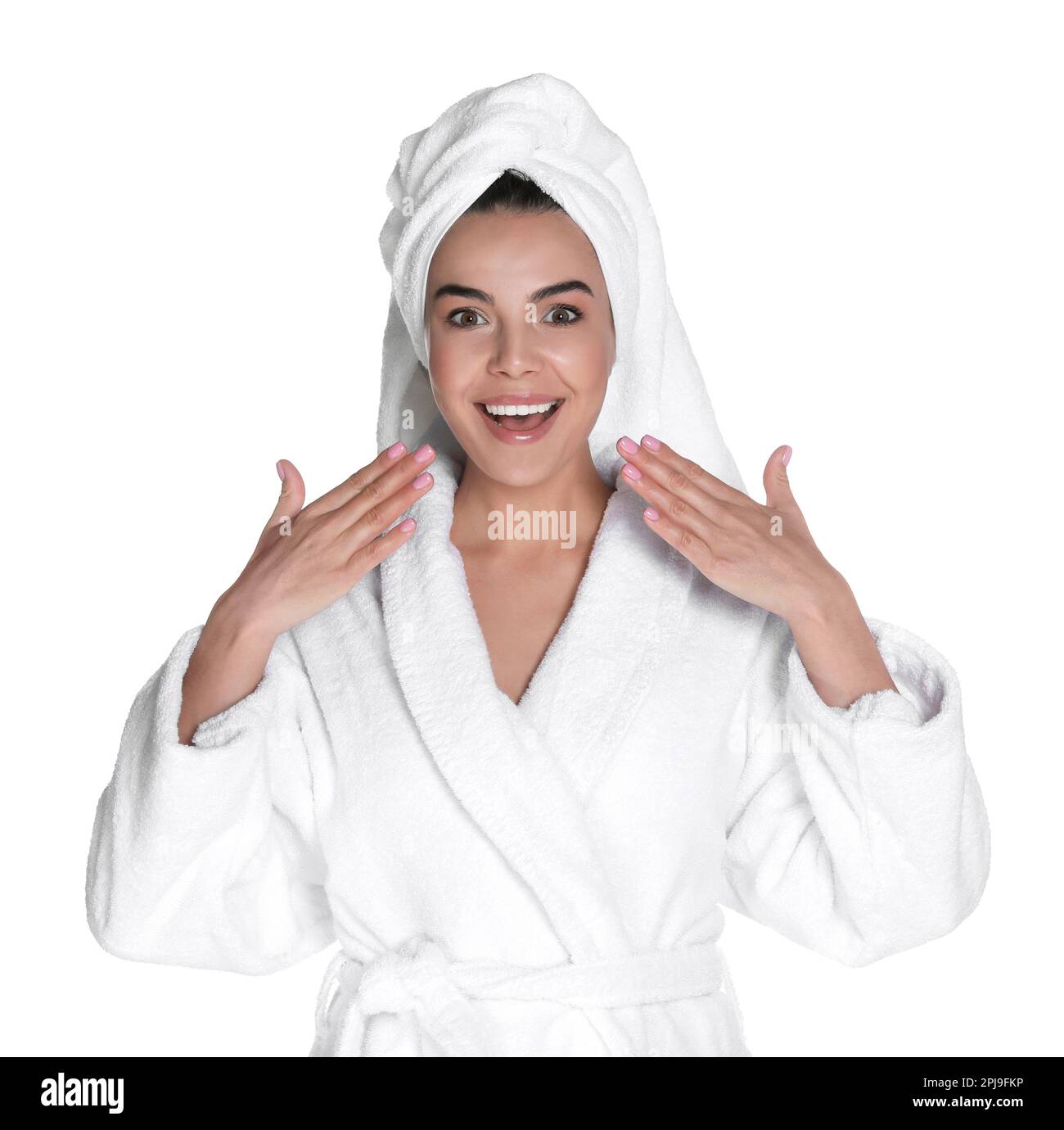 Beautiful young woman wearing bathrobe and towel on head against white