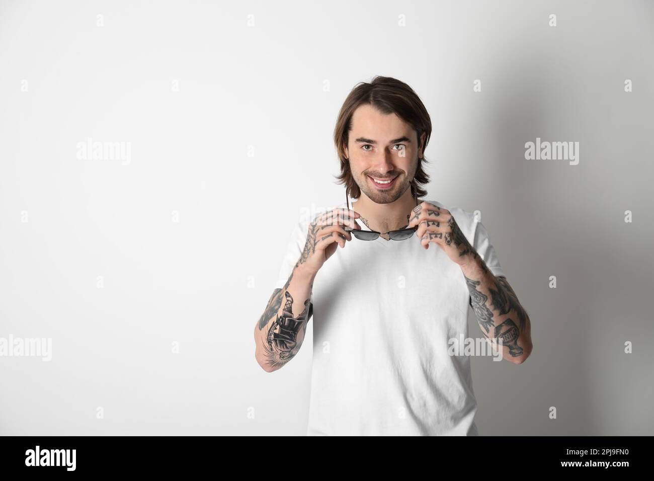 Young man with tattoos on arms against white background Stock Photo - Alamy