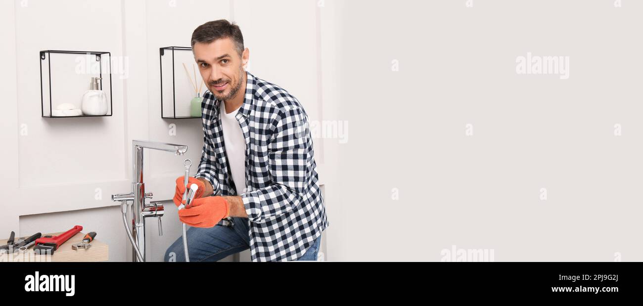 Plumber installing new water tap in bathroom, space for text. Banner design Stock Photo