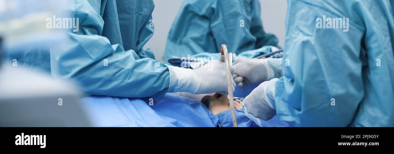 Professional doctors performing frontal sinus trephination in surgery room, closeup. Banner design Stock Photo
