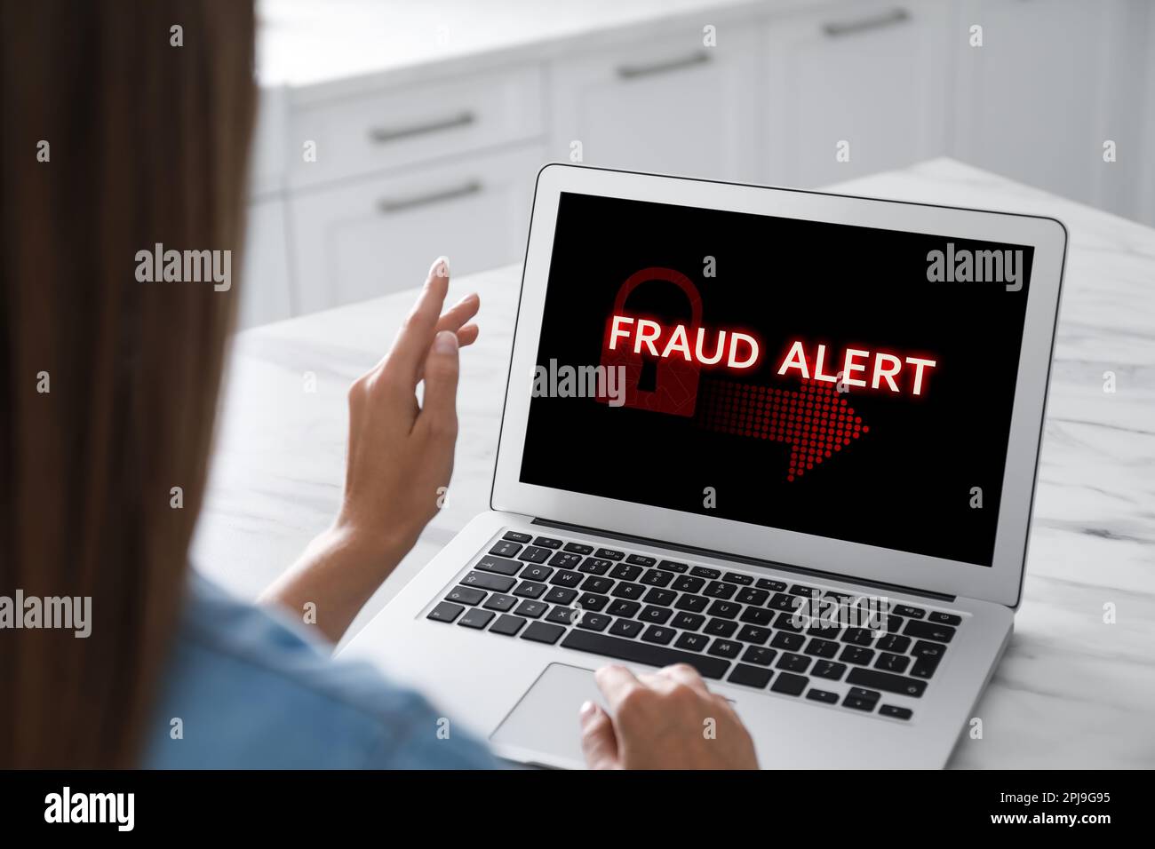 Fraud prevention security system. Woman using laptop at white table, closeup Stock Photo