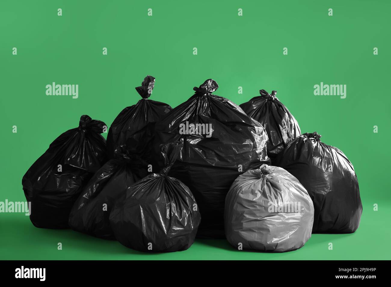 https://c8.alamy.com/comp/2PJ9H9P/trash-bags-full-of-garbage-on-green-background-2PJ9H9P.jpg