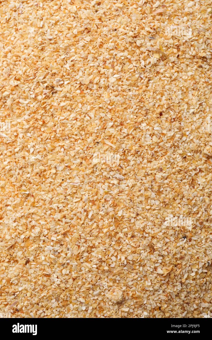 Aromatic dehydrated garlic granules as background, top view Stock Photo