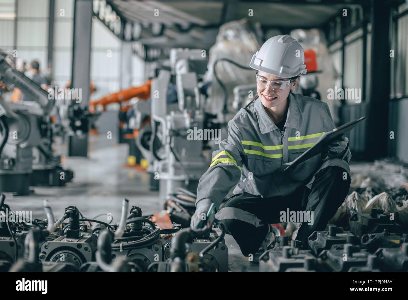 Happy woman engineer worker work in modern machine part factory working check products stock