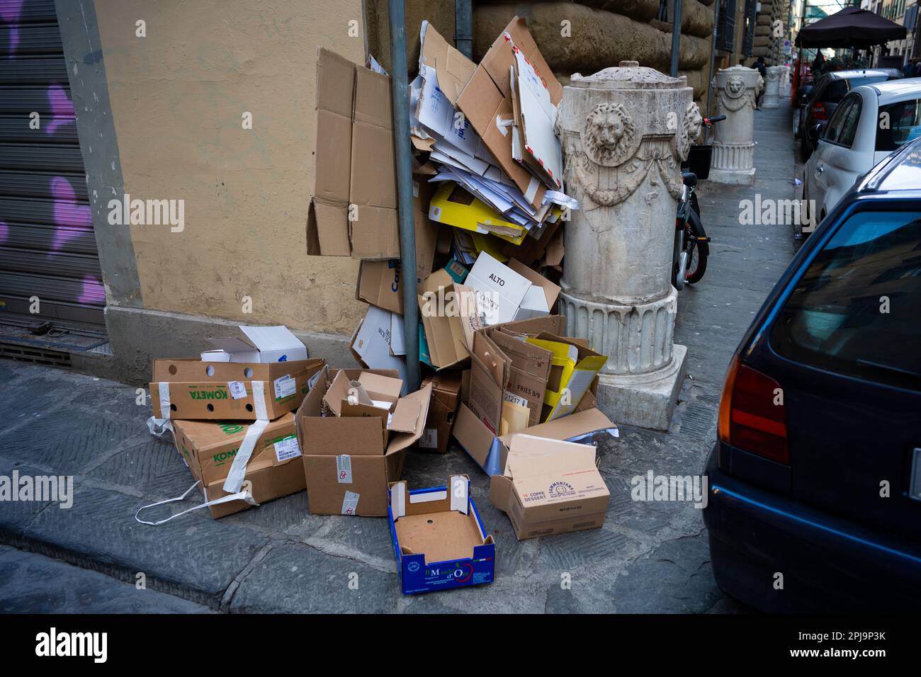 Paper and cardboard piled up on the pavement awaiting collection for