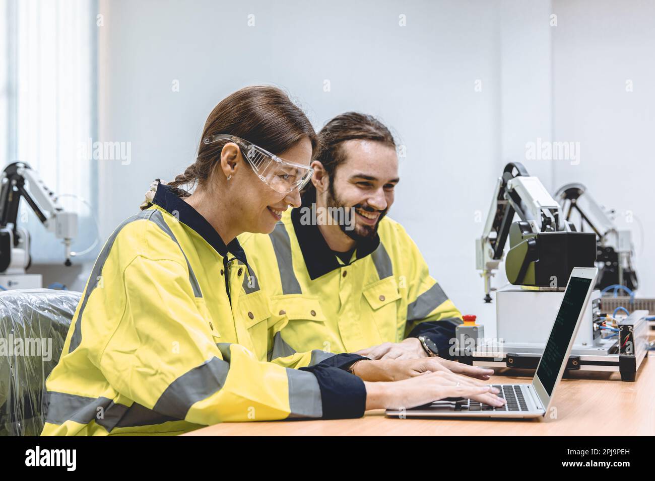 Engineer team software developer happy working together typing program source code for robot control Stock Photo