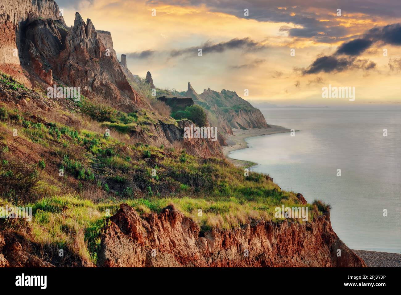 Wild sea coast landscape at the sunset. Colorful clay cliffs and rocks