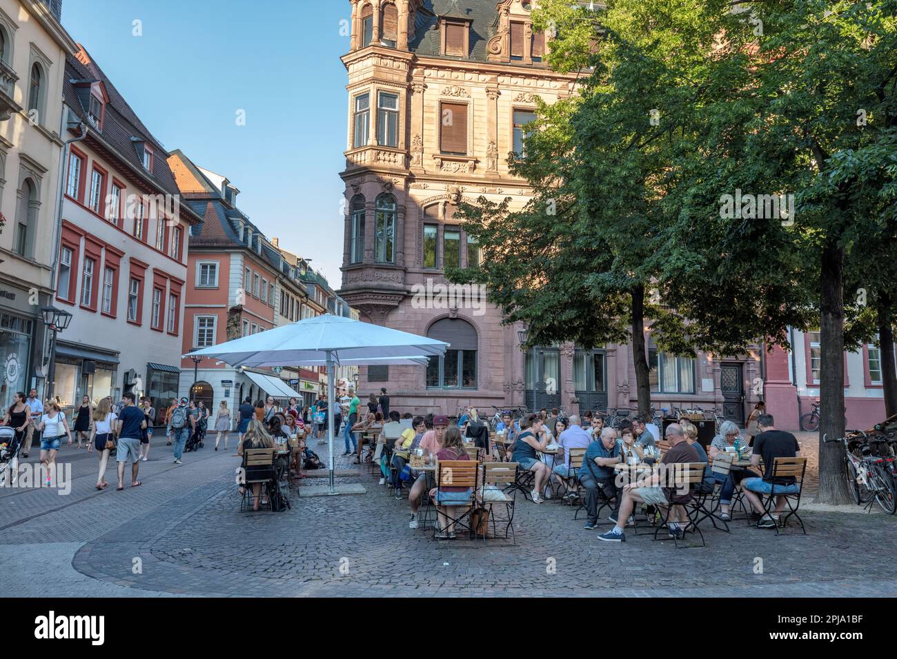 People at cafe and bar in historic Hauptstrasse in Old Town. Heidelberg. Stock Photo