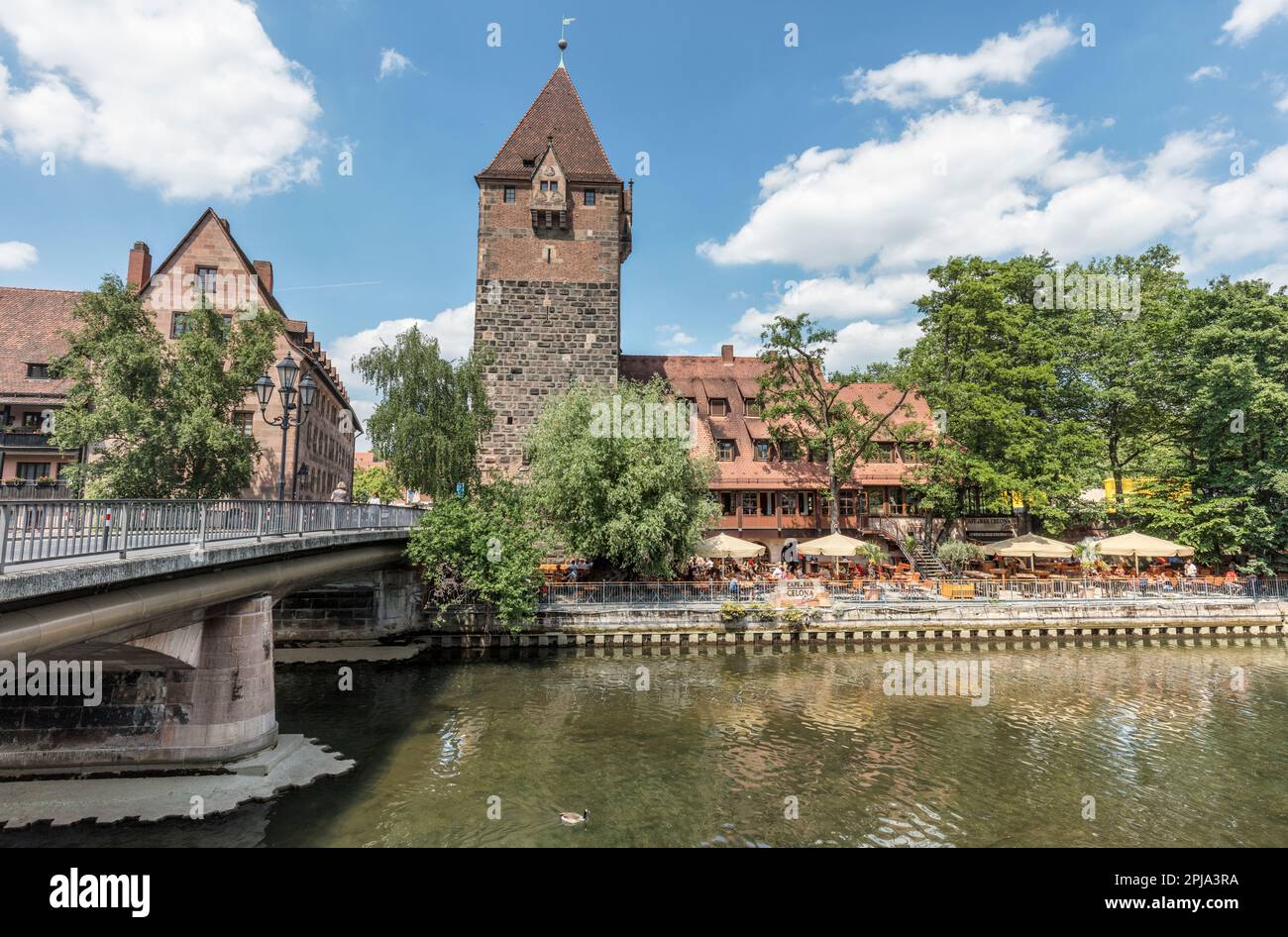 Medieval Schuldturm tower part of the city wall from 1323 by Pegnitz river and Heubrucke bridge. Old Town Altstadt in Vordere Insel Schutt. Nuremberg. Stock Photo