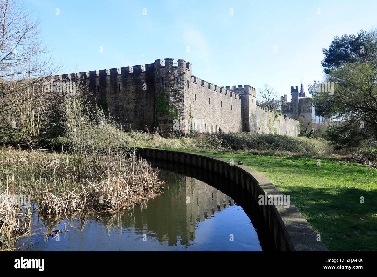 Cardiff Castle walls with reflection,  and Bute feeder canal from  Bute Park scenes. March 2023. Spring Stock Photo