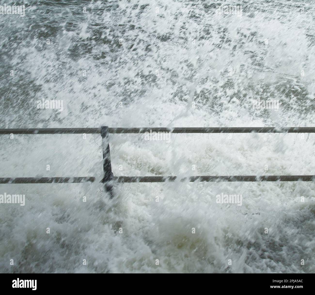 Waves Crashing Over A Metal Barrier During Storm Mathis In The Spring, Mudeford Quay, Christchurch UK Stock Photo