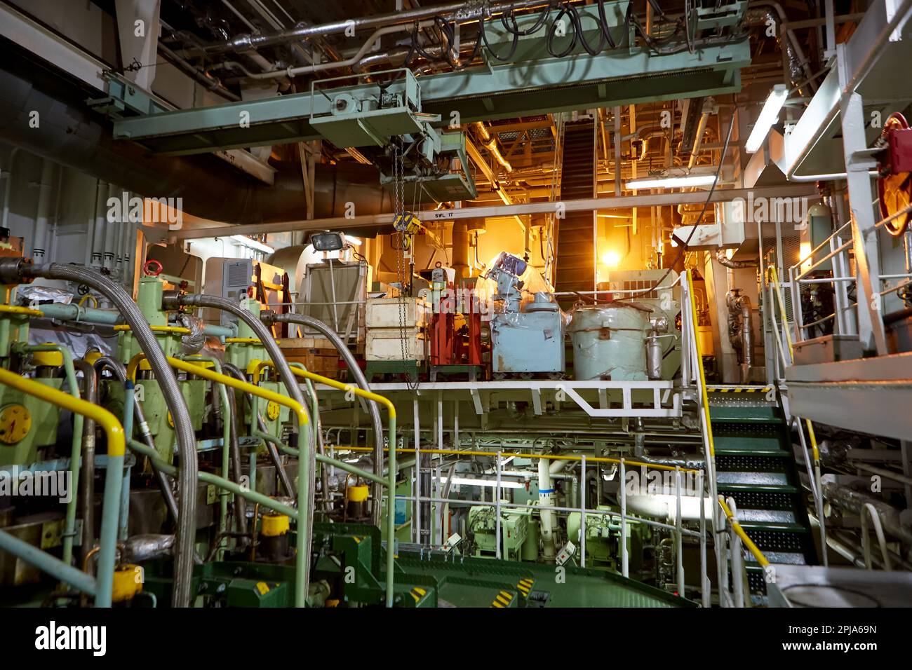Ship's engine room. Vessel's ( Ship ) Engine Room Space / industrial stairs. Ship's Engine Heavy Machinery Space - Pipes, Valves, Engines Stock Photo